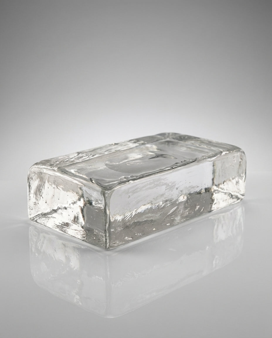Clear glass block on a reflective gray surface
