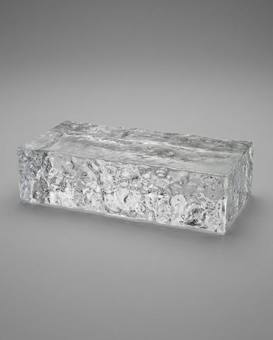 Clear glass block with textured surface on a gray background