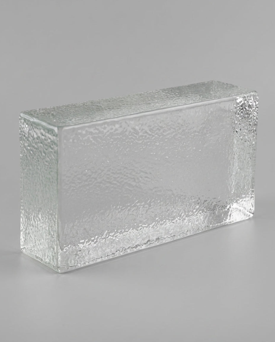 Rectangular glass block with textured surface on a gray background