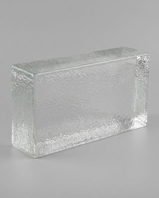 Rectangular glass block with textured surface on a gray background