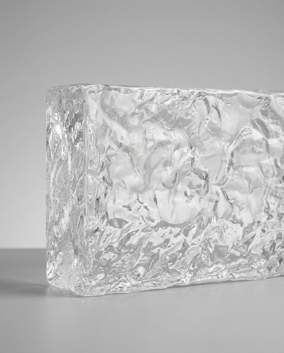 Clear glass block with textured surface on a gray background