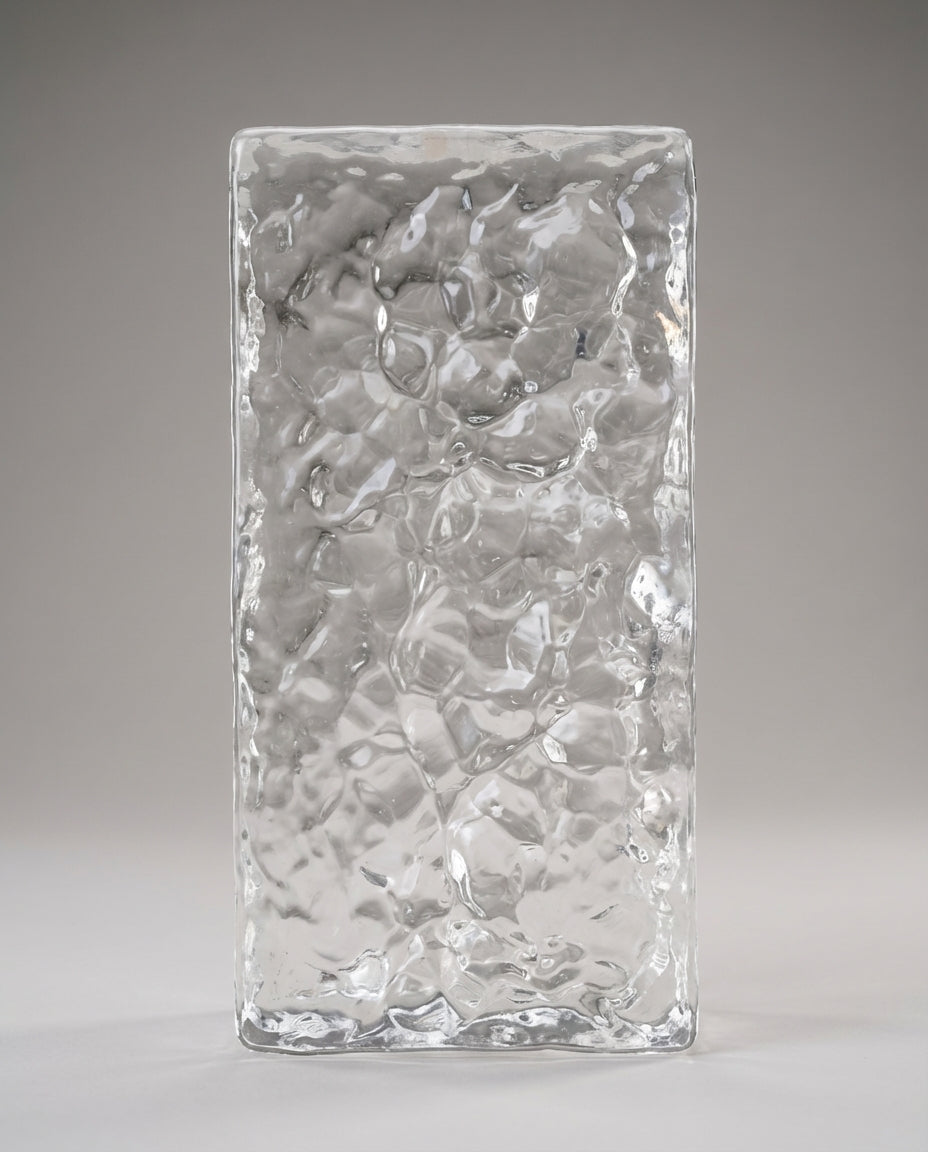 Rectangular glass block with textured surface on a gray background