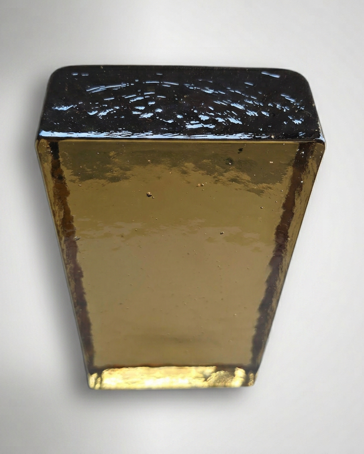 Rectangular wall sconce with gold and black finish on a gray background
